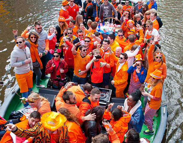 Locals dressed in orange celebrate King's Day on a boat. stock photo