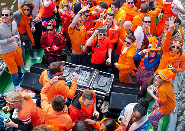 People in orange clothes during King's Day on a boat. stock photo