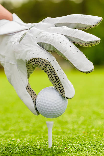 istock woman's hand neatly puts the ball on tee on field 485056948