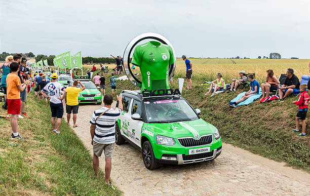 Skoda Caravan on a Cobblestone Road- Tour de France 2015 Quievy,France - July 07, 2015: Skoda Caravan during the passing of the Publicity Caravan on a cobblestoned road in the stage 4 of Le Tour de France on July 7 2015 in Quievy, France. Skoda is the official car of the competition and sponsors the Green Jersey. cycling vest photos stock pictures, royalty-free photos & images