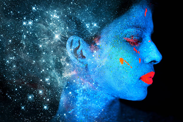 Celestial beauty Shot of a young woman posing with neon paint on her facehttp://195.154.178.81/DATA/i_collage/pi/shoots/784268.jpg negative space illusion stock pictures, royalty-free photos & images