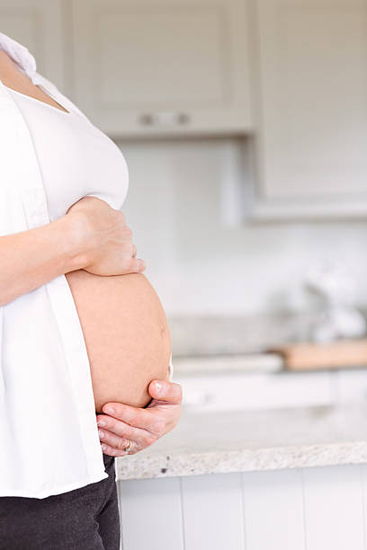 istock Pregnant woman holding her bump 485060256
