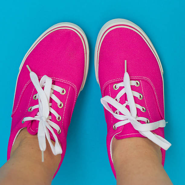 istock Legs in pink sneakers on blue background 485060524