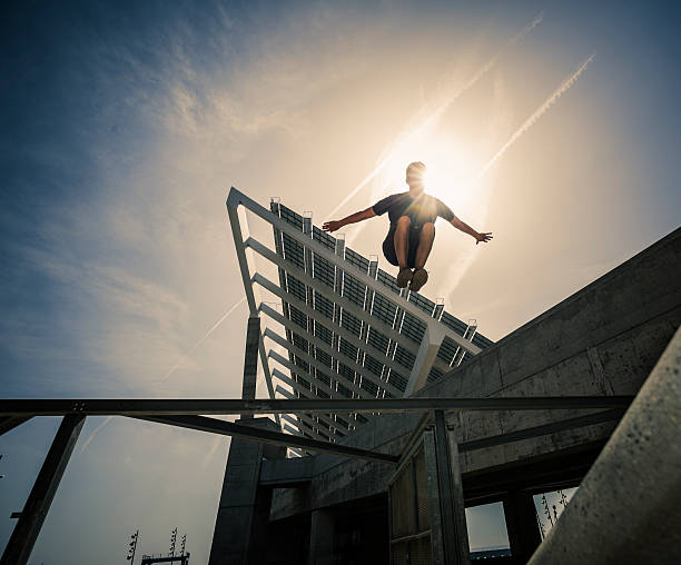 Parkour jumping plotter Young man practicing parkour in the city free running stock pictures, royalty-free photos & images