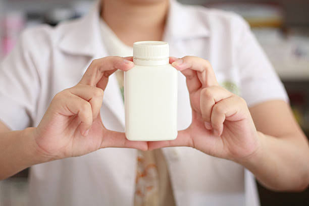 istock pharmacist hand holding medicine bottle 485062306