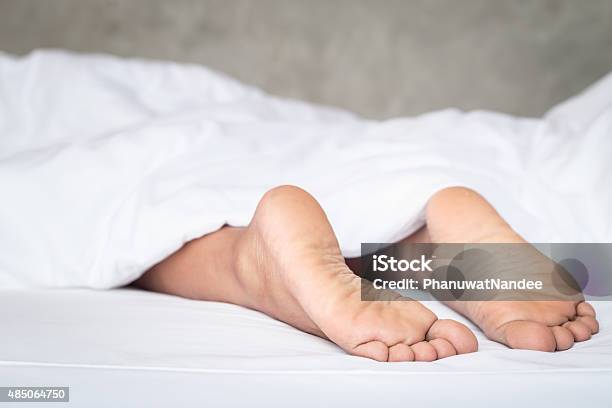 Feet Of Women On White Bedding In The Morning Time Stock Photo - Download Image Now - 2015, Adult, Bed - Furniture