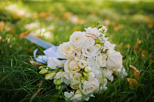 istock wedding bouquet with engagement rings on green grass 485065662
