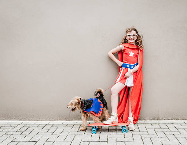 poco chica con su perro superhéroe y monopatín - welsh culture fotos fotografías e imágenes de stock