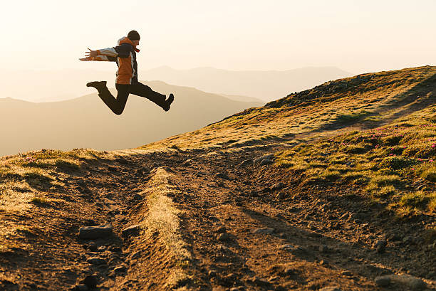 istock Man jumping over mountain road on sunrise 485067550