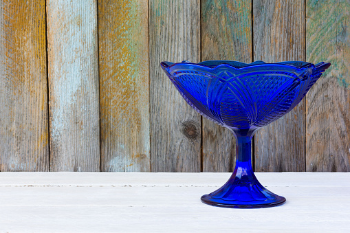 ancient blue empty glass vase for fruit on wooden boards