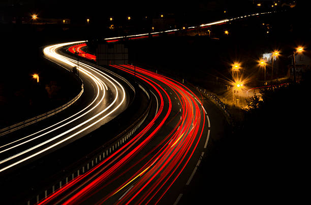 highway lights - curve driving winding road landscape stock-fotos und bilder