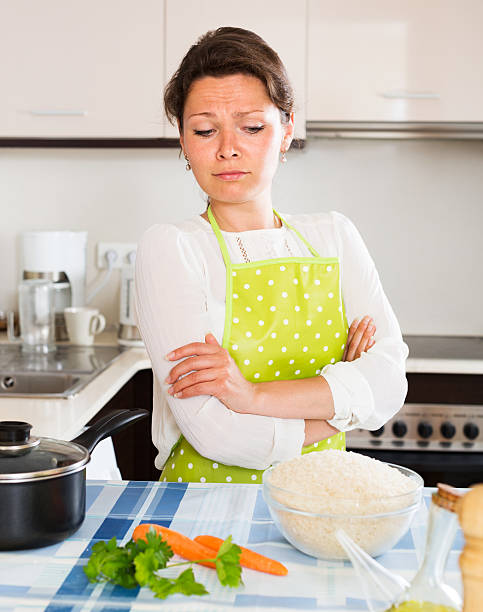 istock Pensive woman cooks rice with vegetables 485076426