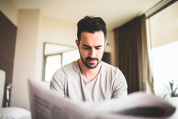 istock man reading the newspaper on bedroom 485081147