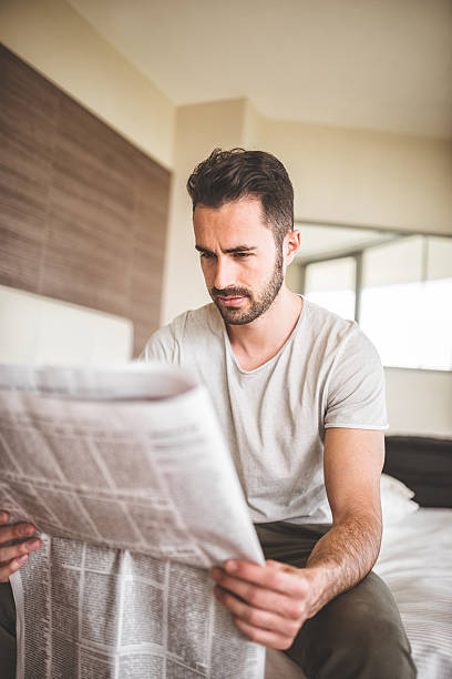 istock man reading the newspaper on bedroom 485081241