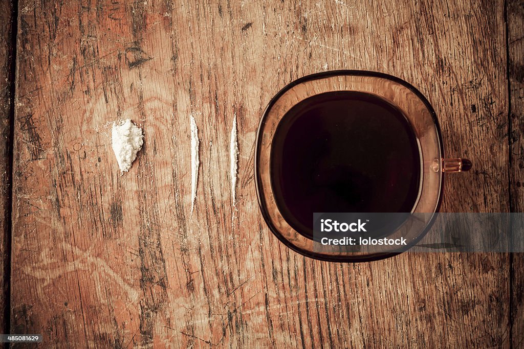 Coffee and cocaine Cup of black coffee with lines of cocaine next to it on  table Abuse Stock Photo