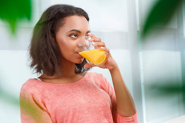 istock Pretty woman drinking orange juice 485082160