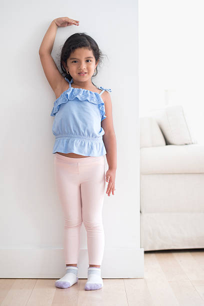istock Girl measuring her height against the wall 485082176
