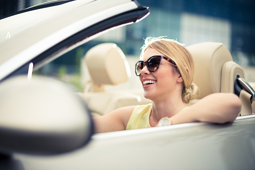 Fashionable woman driving the convertible car.