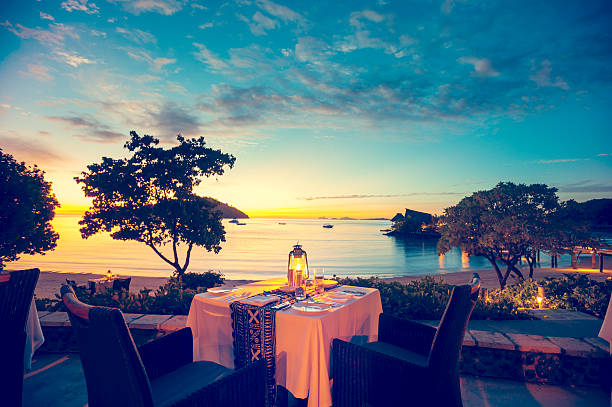 夕暮れのロマンチックな海岸沿いのレストラン - クロスプロセス ストックフォトと画像