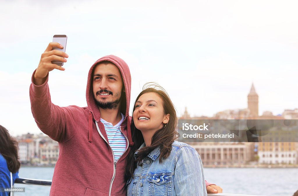 Young couple taking selfie in front of Galata tower; Istanbul Young couple taking selfie in front of Galata tower; Istanbul. 2015 Stock Photo