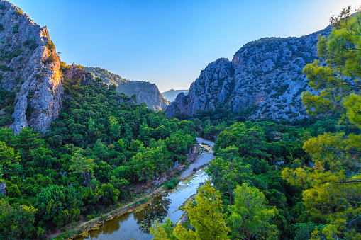 mediterranean coast from high angle in Olympos valley and river, Antalya, Turkey. orange trees and pine tree forest and reflection of sunlight at sunset time with amazing landscape view