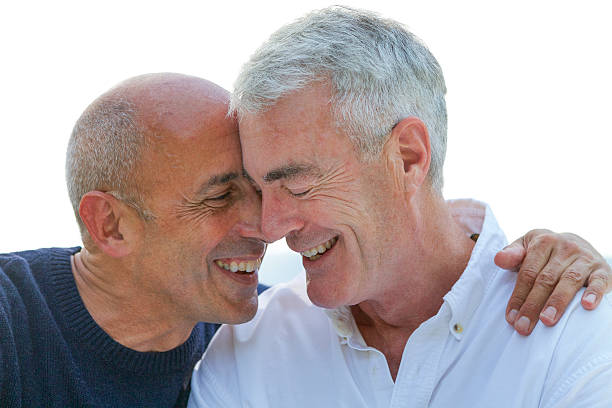 Mature, Older, Senior Gay Male Couple Smiling and Affectionate Mature, older senior gay male couple, smiling and affectionate and in love, in front of white background the hamptons photos stock pictures, royalty-free photos & images