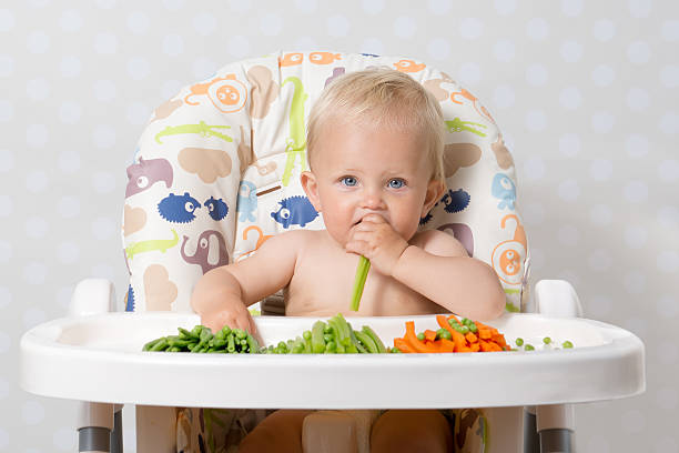 Baby girl eating raw food stock photo