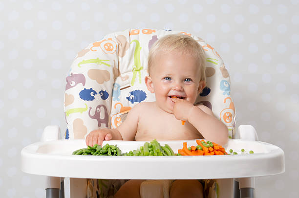 Baby girl eating raw food stock photo