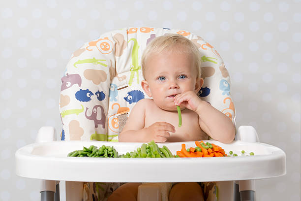 Baby girl eating raw food stock photo