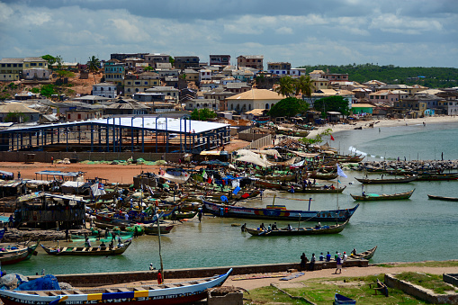 Elmina, Ghana - April 26, 2014: Elmina Castle in Ghana, a former slave transit point from Africa to America, view of the fisherman and market at the dock