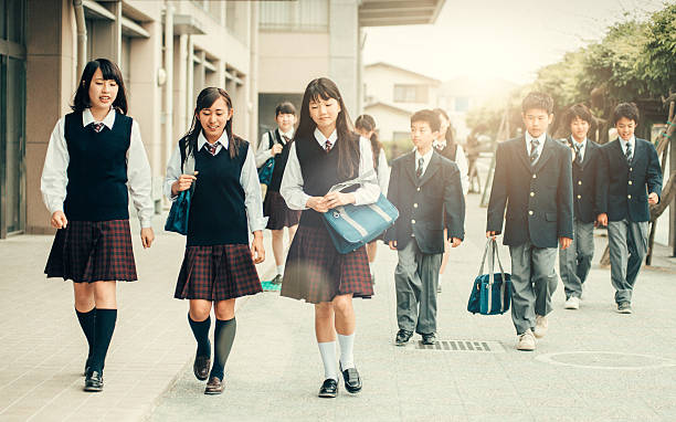 First day of school in Japan Japanese teenage students in uniforms walking back to School japanese boy and girl stock pictures, royalty-free photos & images
