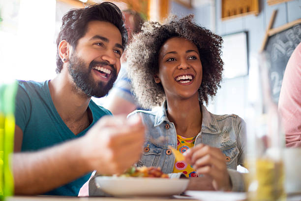 jovem casal comer em uma barra - lanche da tarde imagens e fotografias de stock