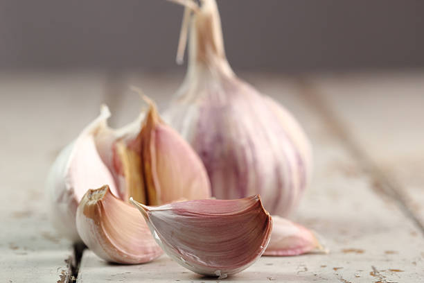 istock Garlic bulbs and cloves on peeling paint plank table 485111837