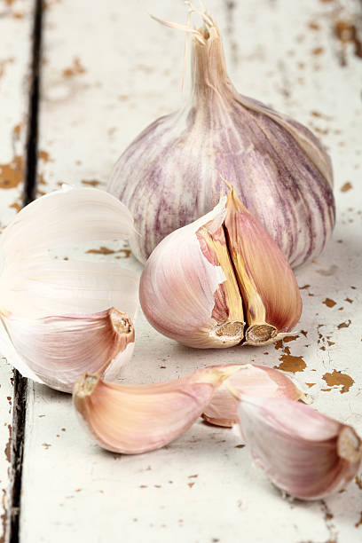 istock Garlic bulbs and cloves on peeling paint plank table 485111843