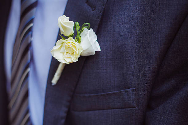 A groom elegantly holding a beautifully arranged wedding bouquet, symbolizing love and anticipation. The image captures a refined and romantic moment before the ceremony.