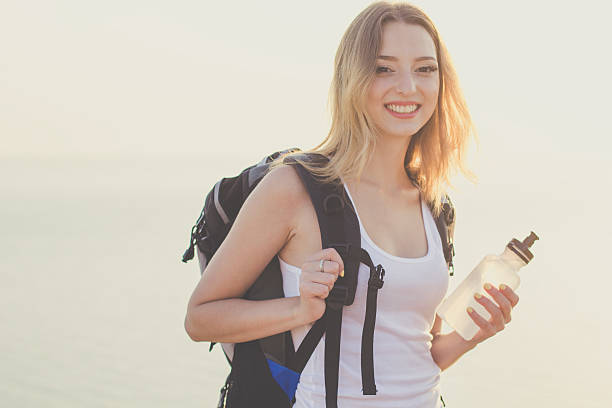 istock Smiling backpacker girl is holding bottle with water 485113142
