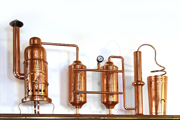 Alembic Copper Alembic Copper - Distillation apparatus employed for the distillation of alcohol. Small model distillery still photos stock pictures, royalty-free photos & images