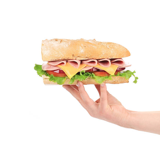 istock Hand holding baguette sandwich. 485113835