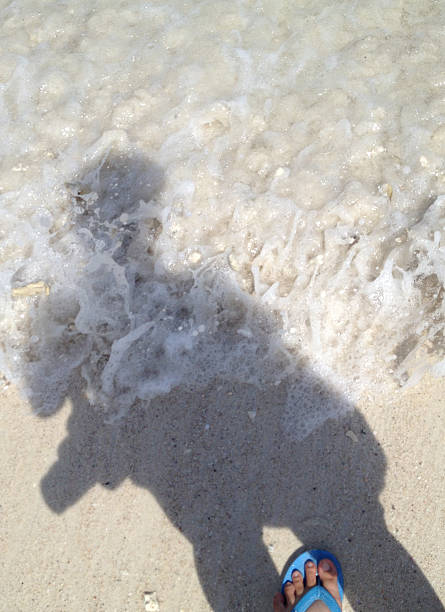 istock traveler shadow with sea wave bubbles foam on the beach 485117362