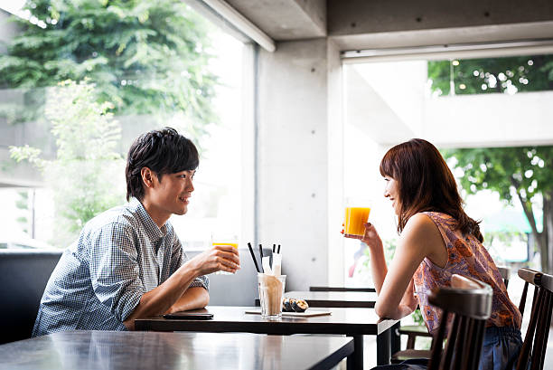 Two cups of coffee and two glasses of orange juice on the table in a café.
