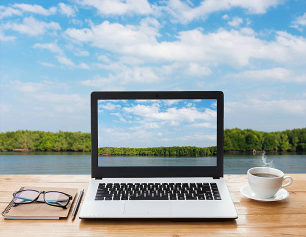 istock laptop and coffee on wood workspace and mangrove forest background 485125282