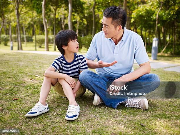 Asian Father And Son Having A Conversation Stock Photo - Download Image Now - Discussion, Child, Talking