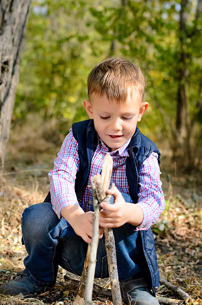 istock Cute Little Boy Playing with Sticks at the Woods 485130428