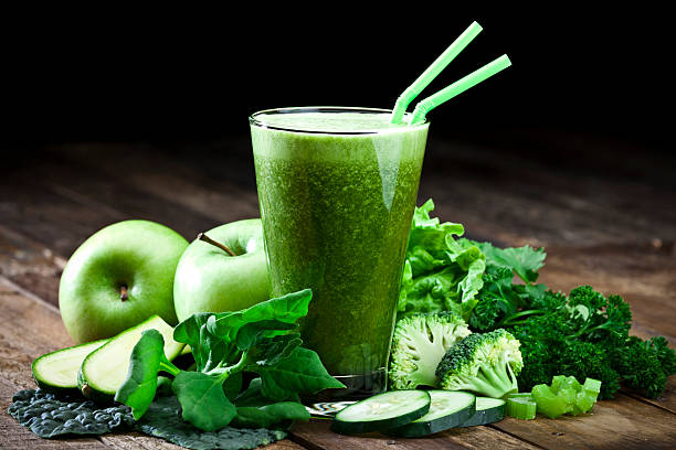 verde jugo de vegetales en mesa de madera rústica - green drink fotografías e imágenes de stock