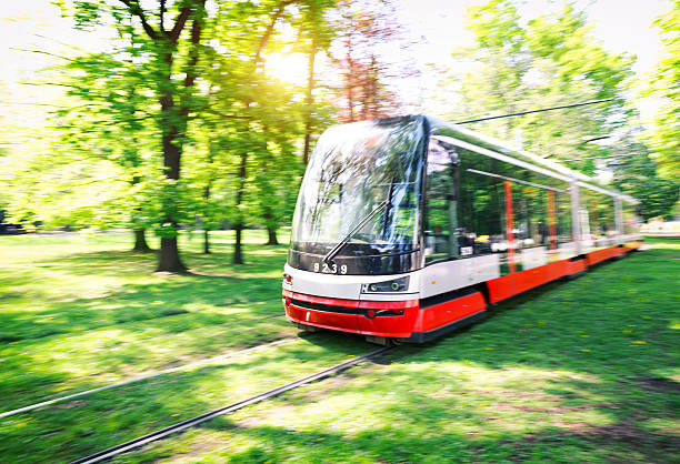 Tram In Prague Moving white and red tram in a green surroundings (Prague, Czech Republic). blurred motion street car green stock pictures, royalty-free photos & images