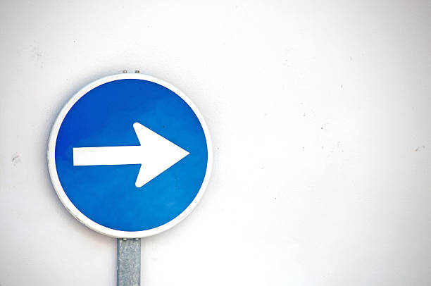 istock Blue traffic directional arrow against white wall- Copy space 485135558