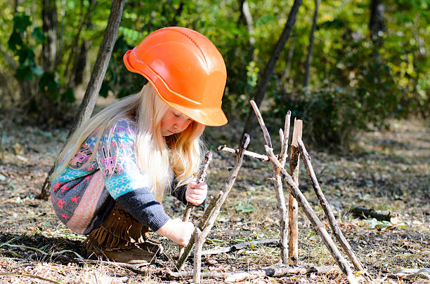 istock Girl With Helmet Assembling Sticks on the Ground 485145628