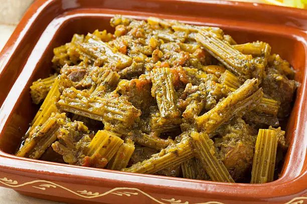 Square tajine with meat and cardoon meal close up