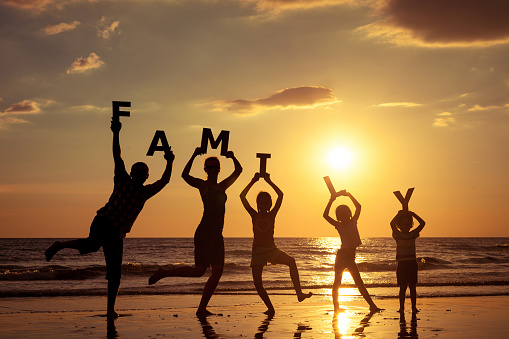 Happy family standing on the beach photo