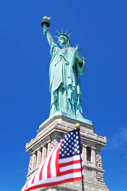 istock Statue of Liberty with small American Flag 485151186